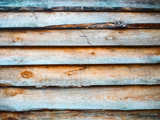 Pine plank fence. Background of pine old natural wood planks. Close-up, light yellow rough surface of a sawn log of a dry pine tree.