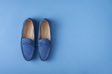 Blue suede man's mocassin shoes over blue background