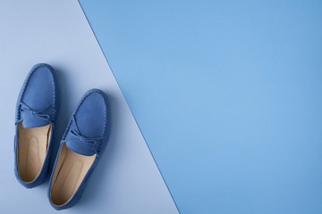 Blue suede man's mocassin shoes over blue background