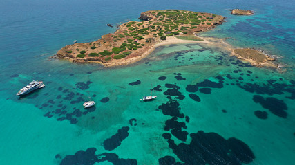 Aerial drone bird's eye view of small islet of Ydrousa with turquoise and sapphire clear waters and...