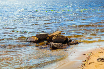 Red stones on the beach. Stones washed by the waves