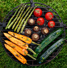 Grilling vegetables with the addition of spices and herbs on the grill plate outdoors, top view....