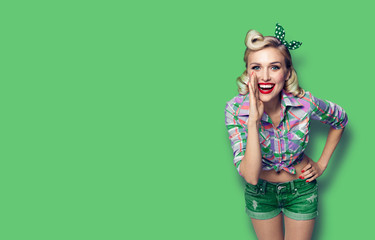 Photo of young happy smiling woman, dressed in pin-up style, over green color background