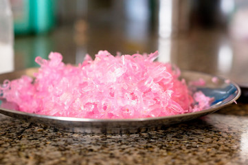 Female grating pink soap for putting into homemade soap