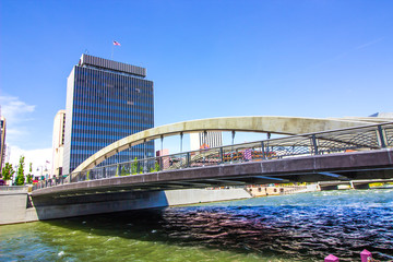 Obraz premium Arched Bridge Over River Into Downtown