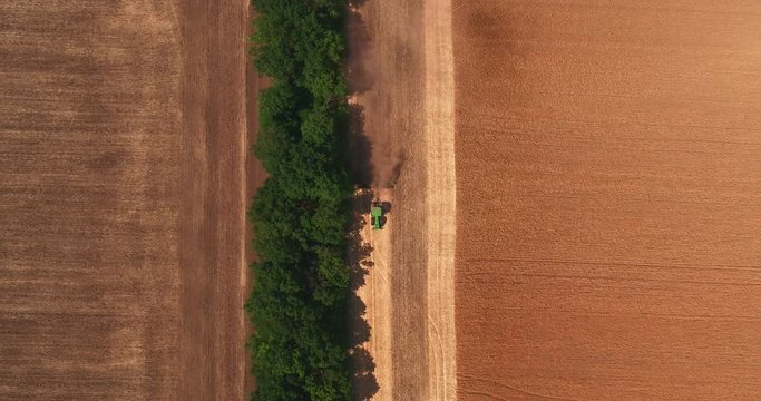 Top view of the tractor ploughing up the field after gathering in wheat