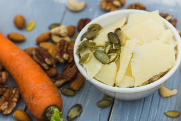 Grana padano cheese, walnuts, cashews, pumpkin seeds and carrot. Healthy life and ketogenic diet concept