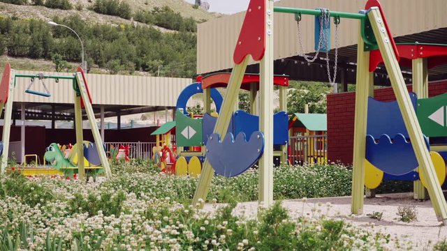 Cozy large playground in kindergarten with flowers and green plants