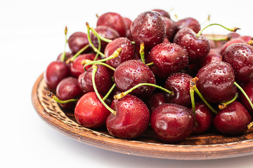 Fresh organic cherries on the clay plate macro view.