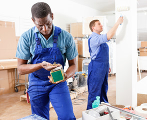 Two male builders working at indoors building site