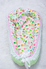 Mattress cocoon and orthopedic pillow for newborns. Bedding for a baby cot. Mattress decorated with...