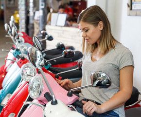 Obraz na płótnie Canvas Young female is choosing modern motobikes