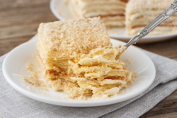 Layered cake with cream Napoleon millefeuille vanilla slice on a white plate.