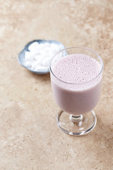 Glass of protein shake with milk and raspberries and BCAA amino acids. Nutrition for bodybuilding. Copy space.