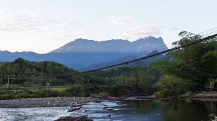 Naklejka na ściany i meble Suspension bridge with Mt. Kinabalu on the background.