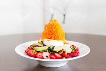 Fresh strawberry, apples, nuts, carrot shavings and cheese salad