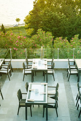 A cozy wicker table in the outdoor cafe-bar on the rooftop in the morning with view on a sea,