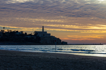 Obraz premium Old Jaffa in silhouette from a nearby beach