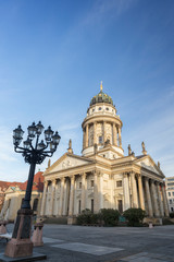 Old streetlight and Französischer Dom (French Cathedral) at the Gendarmenmarkt Square in Berlin, Germany, on a sunny morning. Copy space.