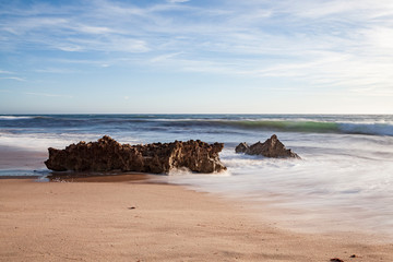 Fototapeta na wymiar Rochas na rebentação das ondas, no areal da praia, na “Praia da Ilha” em Porto Covo (Costa Vicentina), Alentejo, Portugal, Europa.