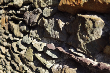 Old grey granite wall built of ancient stonework, abstract background with place for text and selective focus.