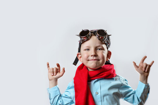 boy in blue shirt, red scarf, biker glasses and bandana on light background