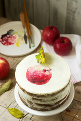 Apple cake with curd cream, decorated with painted apple on the background of autumn composition. Rustic style.