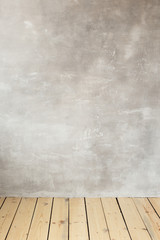 Empty gray concrete wall. Wooden floor. Free space for text.