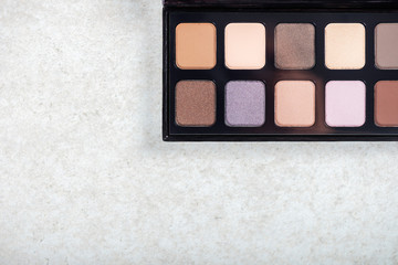 Neutral color eye shadows palette on grey background