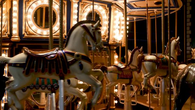 Illuminated merry go round in park. Brightly illuminated roundabout spinning in wonderful amusement park at night.