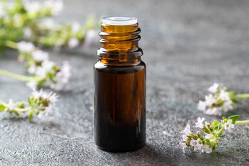 A bottle of thyme essential oil with fresh thyme
