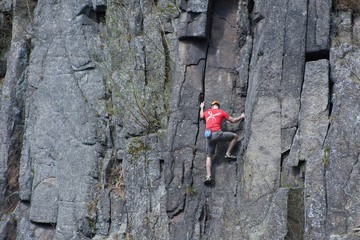 Climber climbs on sandstone rock.