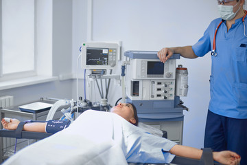 Several doctors surrounding patient on operation table during t