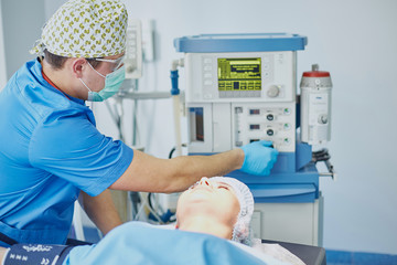 Several doctors surrounding patient on operation table during t