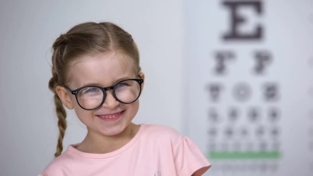 Adorable happy girl wearing glasses, laughing into camera, comfortable eyewear
