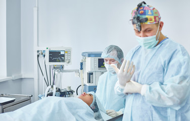 Several doctors surrounding patient on operation table during t