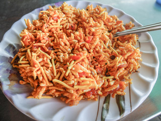 Indian snack,vegetable rice with fried noodles and tomatoes.