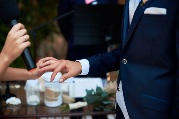 Bride putting a ring on groom's finger