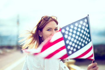 Young patriot modern woman holding USA flag depth of field