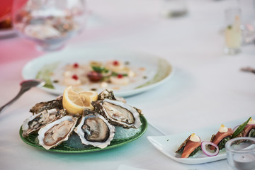 Close-up of fresh oysters with lemon on the restaurant table.