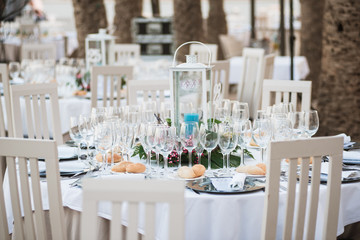 Decorated tables for a wedding reception at beach resort with palms.