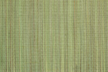 Wicker bast beach mat background. Texture of green beach mat made of bast fibers. The surface of...