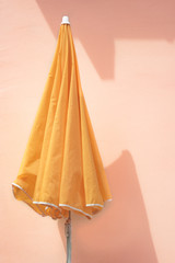 Yellow parasol on a pink wall