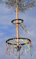 Im Wind wehendes Krepp-Papier an einem bunt geschmückten Maibaum