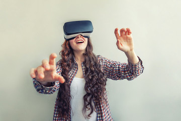 Smile young woman wearing using virtual reality VR glasses helmet headset on white background. Smartphone using with virtual reality goggles. Technology, simulation, hi-tech, videogame concept