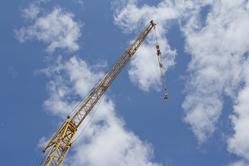 Crane boom on blue sky background. Crane lifting mechanism.