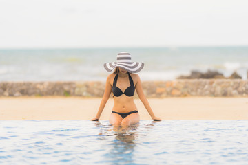 Portrait beautiful young asian woman wear bikini around swimming pool in hotel resort nearly sea ocean beach