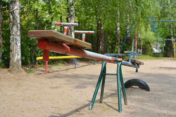 Empty old seesaw with chipped colors at children playground