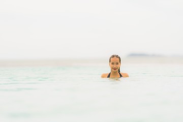 Fototapeta na wymiar Portrait beautiful young asian woman wear bikini around swimming pool in hotel resort nearly sea ocean beach