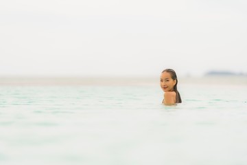 Portrait beautiful young asian woman wear bikini around swimming pool in hotel resort nearly sea ocean beach